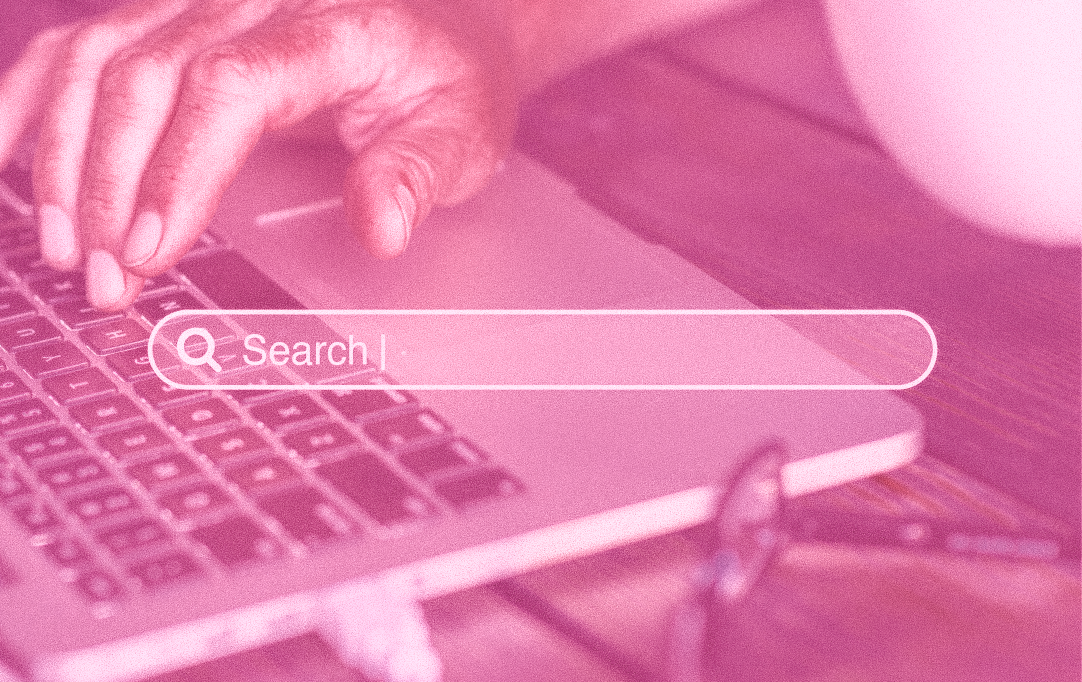 a person's hand on their laptop with a search engine tab overlayed across the picture