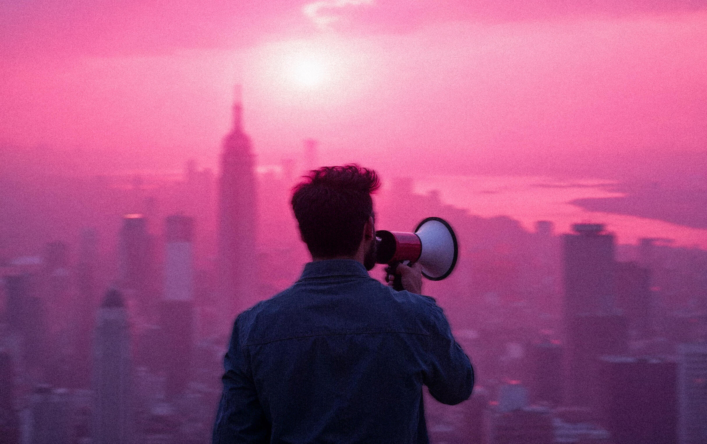 a person yelling into a megaphone, overlooking a city landscape
